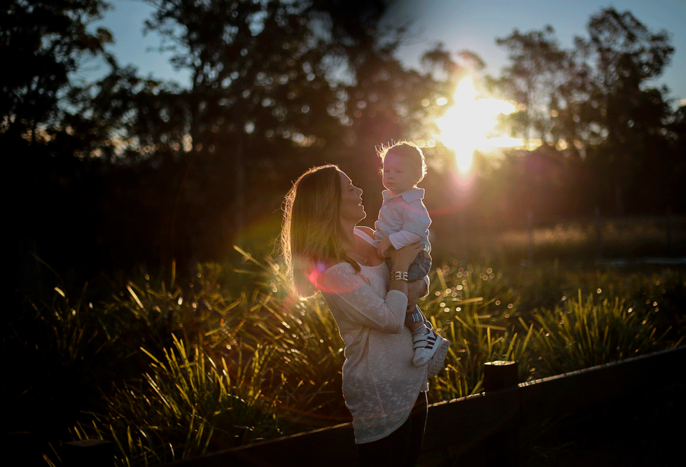 Mum-playing-with-toddler-son-lifting-him-oin-the-air-infront-of-a-magical-gold-coast-sunset