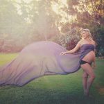 Pregnant Women with long purple fabric maternity photograph
