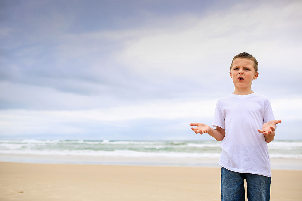 boy-questioning-why-the-family-needs-to-have-an-early-morning-beach-family-photography-session-gold-coast