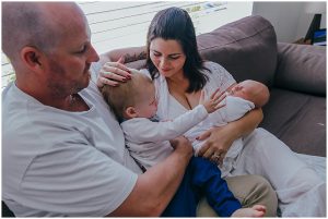 toddler-reaching-for-new-baby-brother-with-mum-and-dad-gold-coast-lifestyle-photography