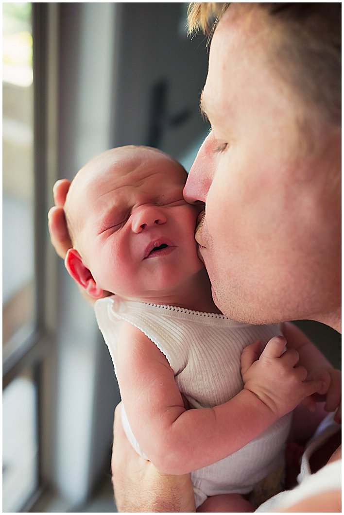 Newborn-getting-dad-kisses-and-reacting-gold-coast-newborn-inhome-photography