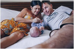 gold-coast-mum-and-dad-talk-with-newborn-son-at-gold-coast-newborn-family-documentary-photography-session