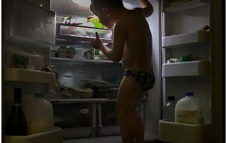 young-boy-doing-his-everyday-climb-up-into-the-fridge-after-a-swim-looking-for-a-snack