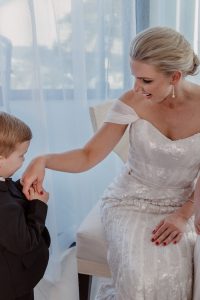Page-image-young-son-kissing-the-hand-of-his-mum-on-her-wedding-day-dressed-and-ready-to-walk-down-the-aisle-gold-coast-family-documentary-photography