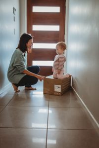 mum-and-baby-in-hallway-playing-with-cardboard-box-baby-is-very-amused-gold-coast-family-photography