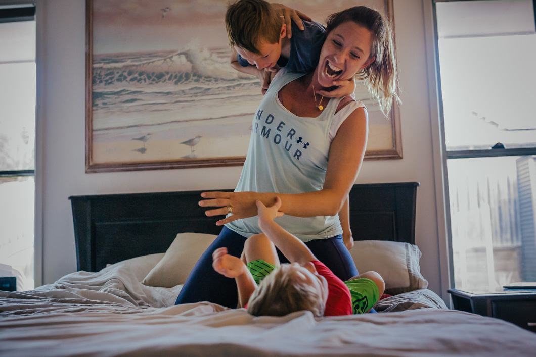 Two-kids-jumping-on-the-bed-with-mum-in-front-of-painting-that-was-their-grandmas-part-of-a-remembering-mum-series-gold-coast-australia-family-documentary-photography