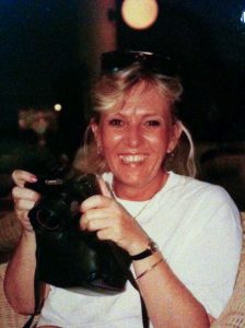 Carol_Weber-holding-camera-with-huge-smile-Flame-of-a-woman