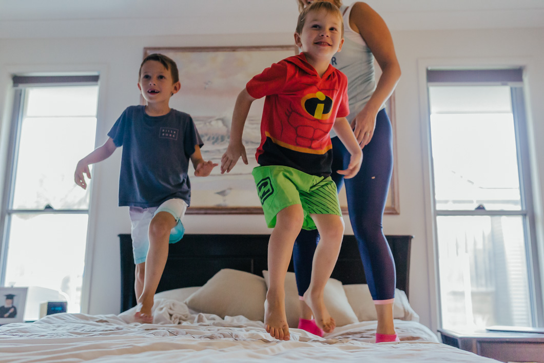 blog-image-Two-kids-jumping-on-the-bed-with-mum-in-front-of-painting-that-was-their-grandmas-part-of-a-remembering-mum-series-gold-coast-australia-family-documentary-photography