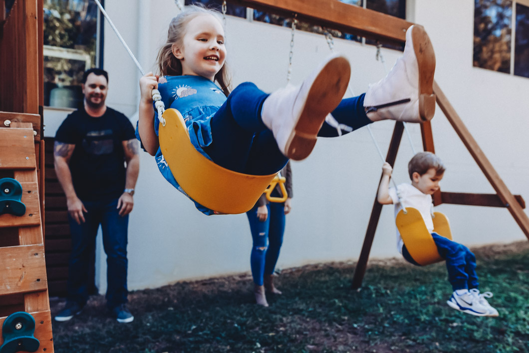 Girl-being-pushed-on-swing-at-home-as-part-of-family-short-story-telling-photography-session