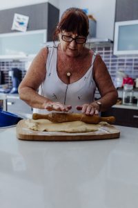 grandma-rolloing-out-christmas-shortbread-dough-with-rolling-pin