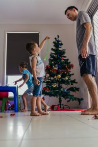 Kids-working-with-dad-to-put-christmas-decoratiions-onto-christmas tree