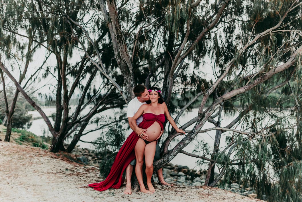 Beautiful-couple-with-pregnant-wife-showing-full-round-expecting-belly-at-currumbin-beach