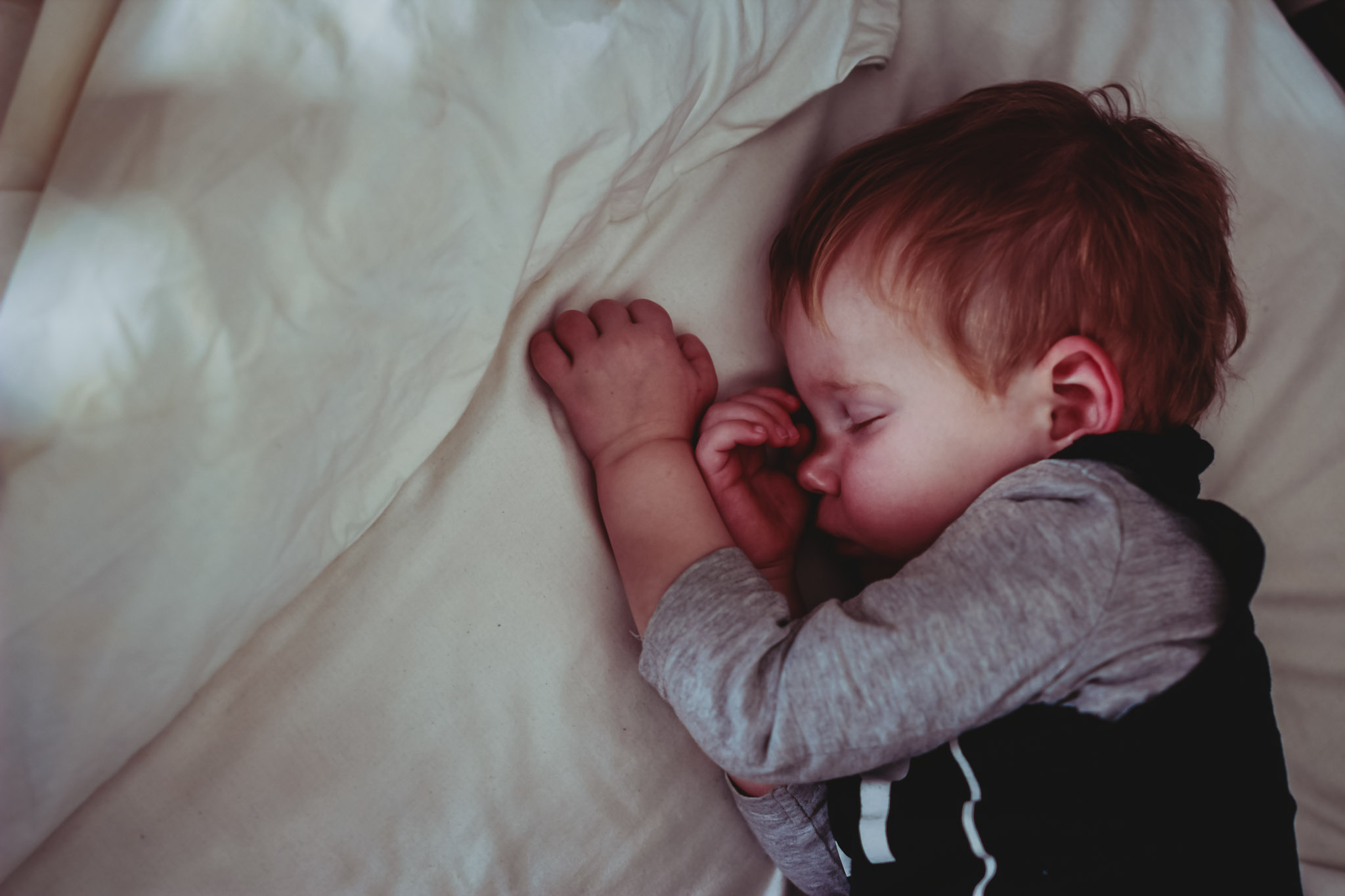 beautiful-toddler-boy-takes-a-nap-in-his-cot-after-a-big-morning-of-laying