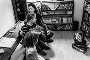 3 girls playing in the home school room with mum when the youngest makes a crazy face at the photographer