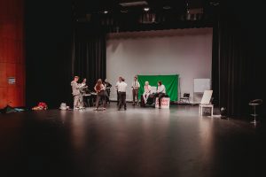 View of front stage during a technical rehearsal of Live at Five Thearte production on the Gold Coast with actor gathered on set preparing for run through of play