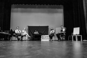 Black and white Cast on stage receiving direction from director live at five