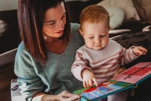 a beautiful Mumma reads her one year old daughter a story book